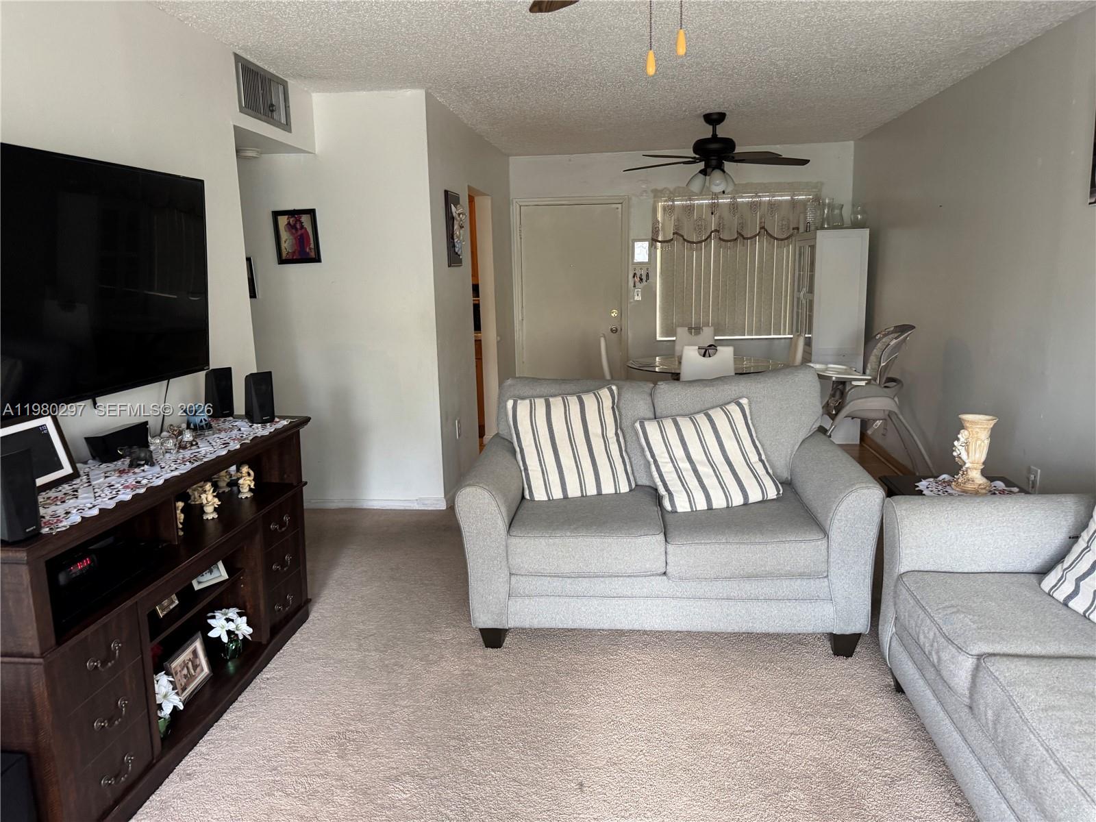 6507 Winfield Boulevard, Unit 111AC Margate, FL 33063 - Photo 14 of 42 a living room with furniture and a flat screen tv