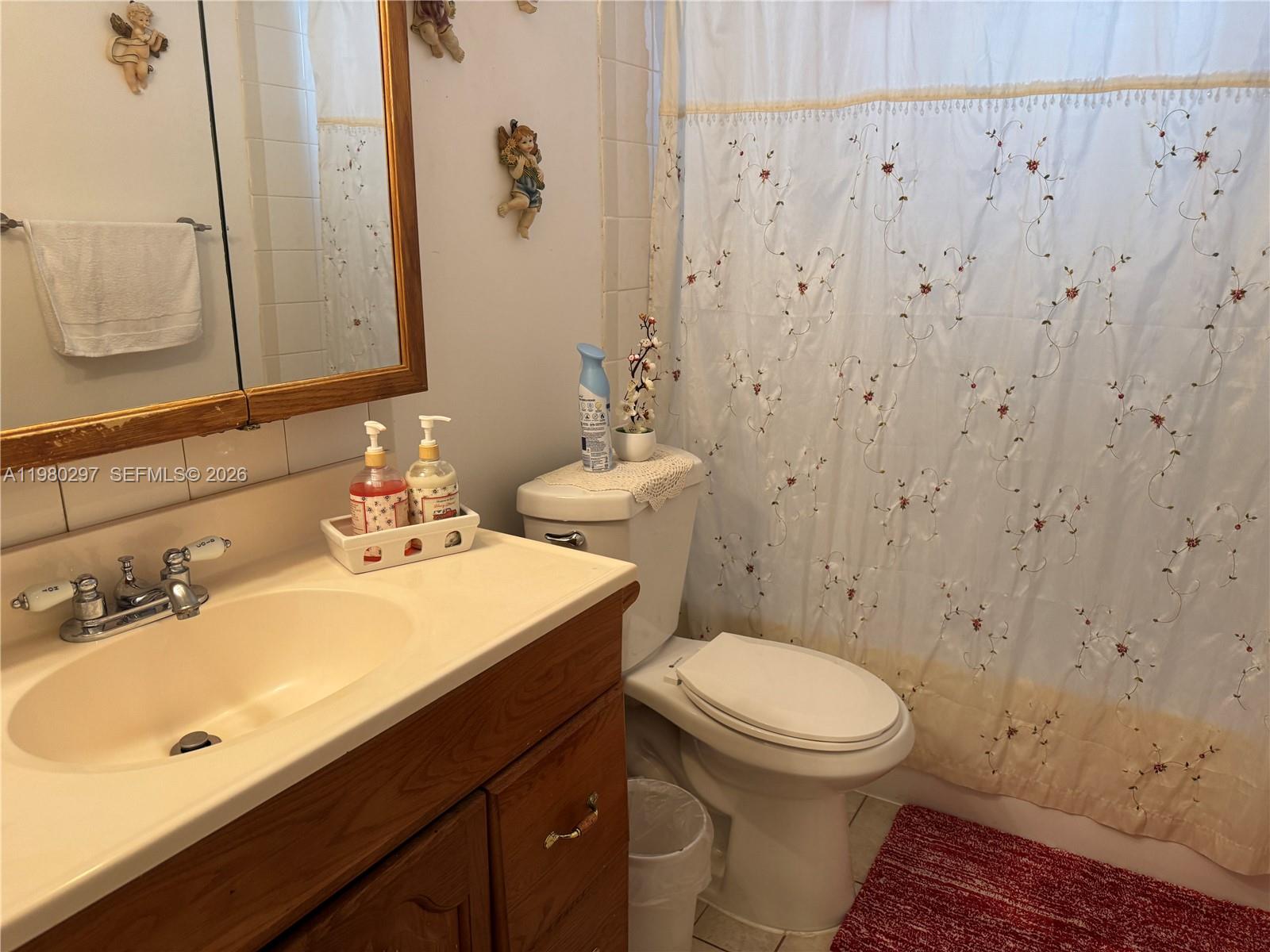 6507 Winfield Boulevard, Unit 111AC Margate, FL 33063 - Photo 20 of 42 a bathroom with a sink a toilet and mirror