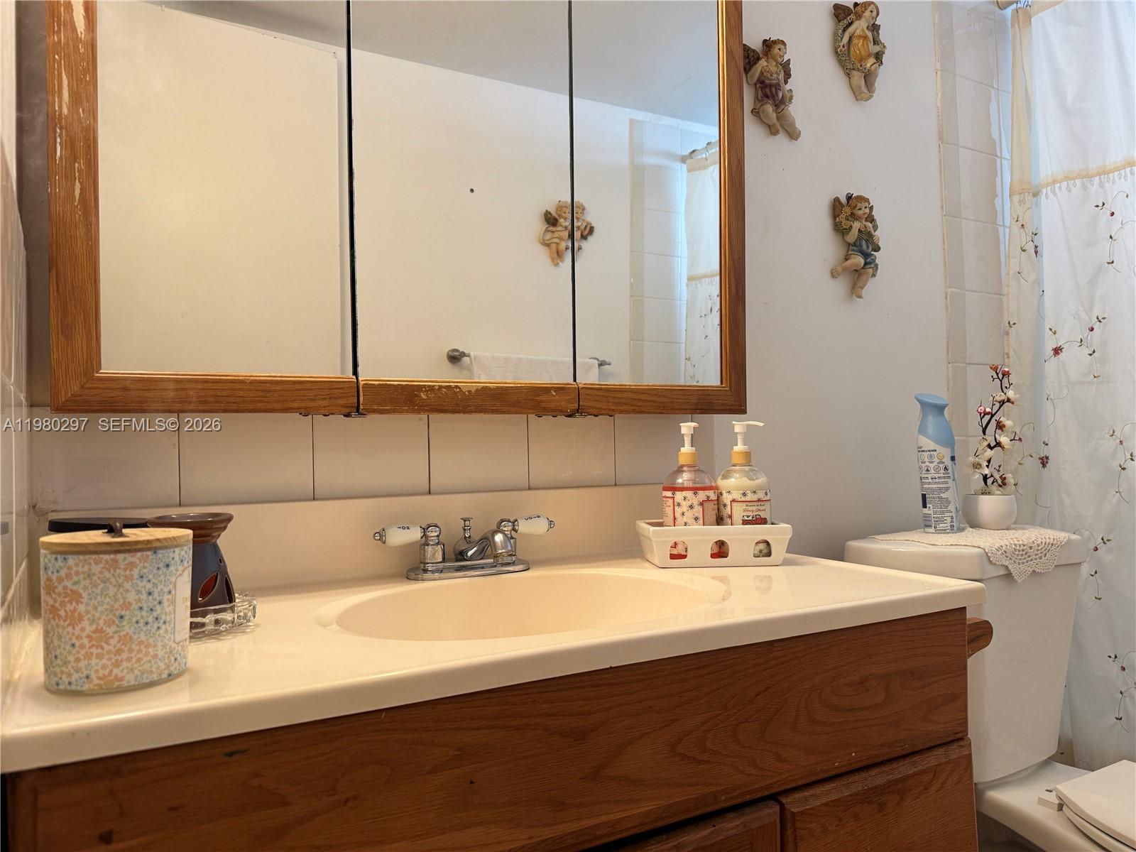 6507 Winfield Boulevard, Unit 111AC Margate, FL 33063 - Photo 21 of 42 a bathroom with a sink and a mirror