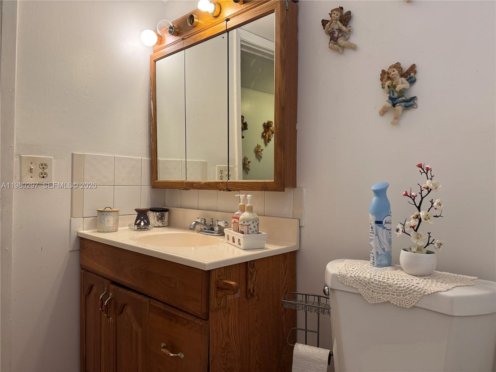 6507 Winfield Boulevard, Unit 111AC Margate, FL 33063 - Photo 23 of 42 a bathroom with a sink and a mirror