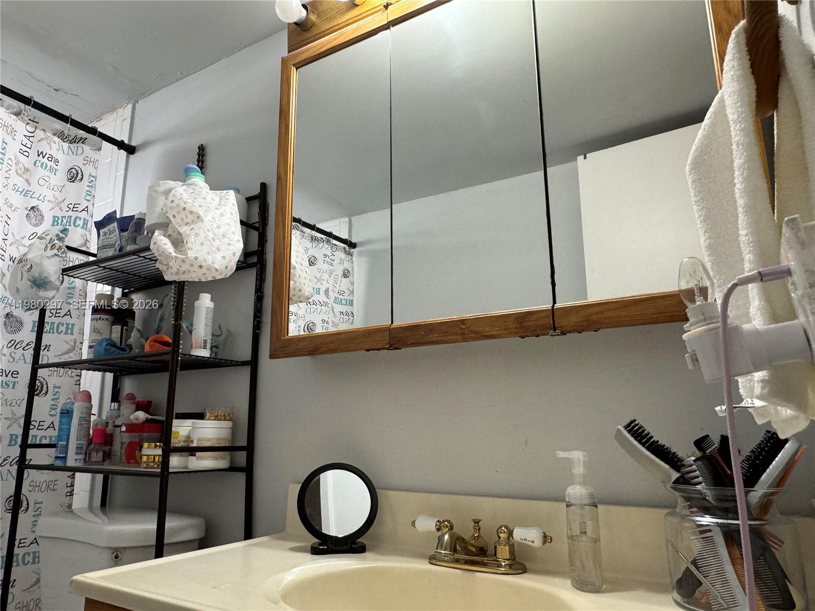 6507 Winfield Boulevard, Unit 111AC Margate, FL 33063 - Photo 26 of 42 a bathroom with a sink mirror and vanity