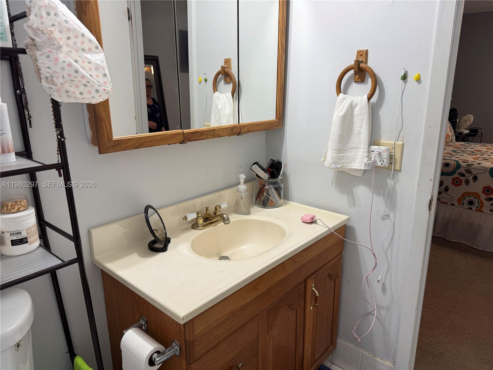 6507 Winfield Boulevard, Unit 111AC Margate, FL 33063 - Photo 29 of 42 a bathroom with a sink and mirror with toilet