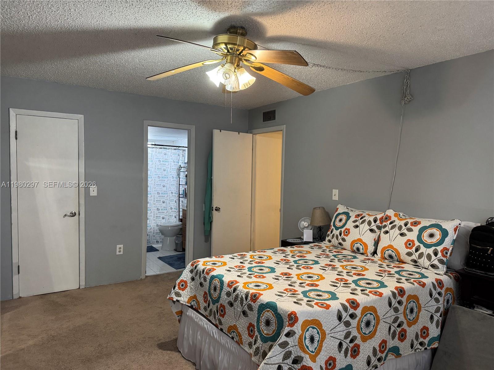 6507 Winfield Boulevard, Unit 111AC Margate, FL 33063 - Photo 33 of 42 a bedroom with a bed and a chandelier