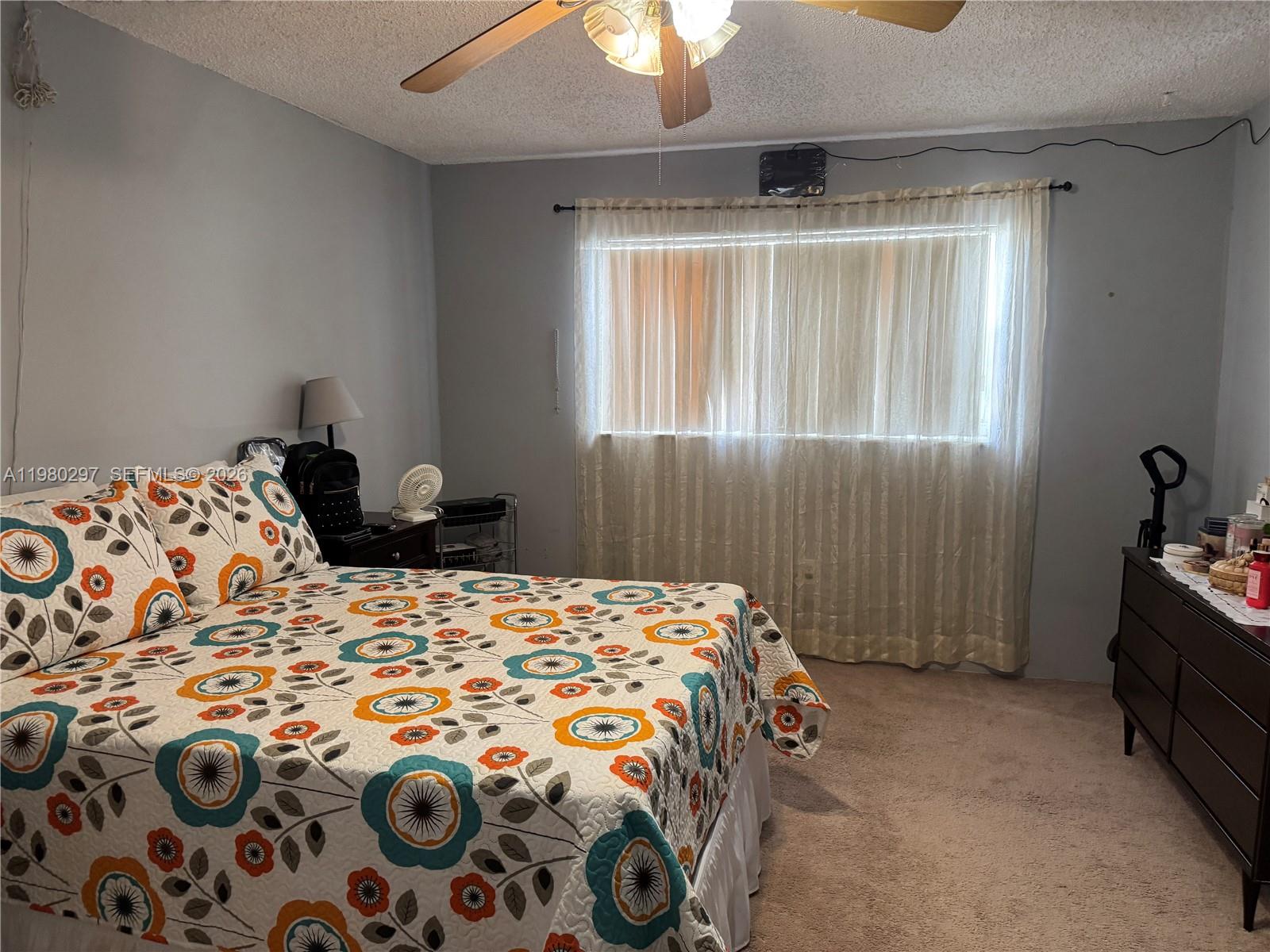 6507 Winfield Boulevard, Unit 111AC Margate, FL 33063 - Photo 35 of 42 a bedroom with a bed and a chandelier