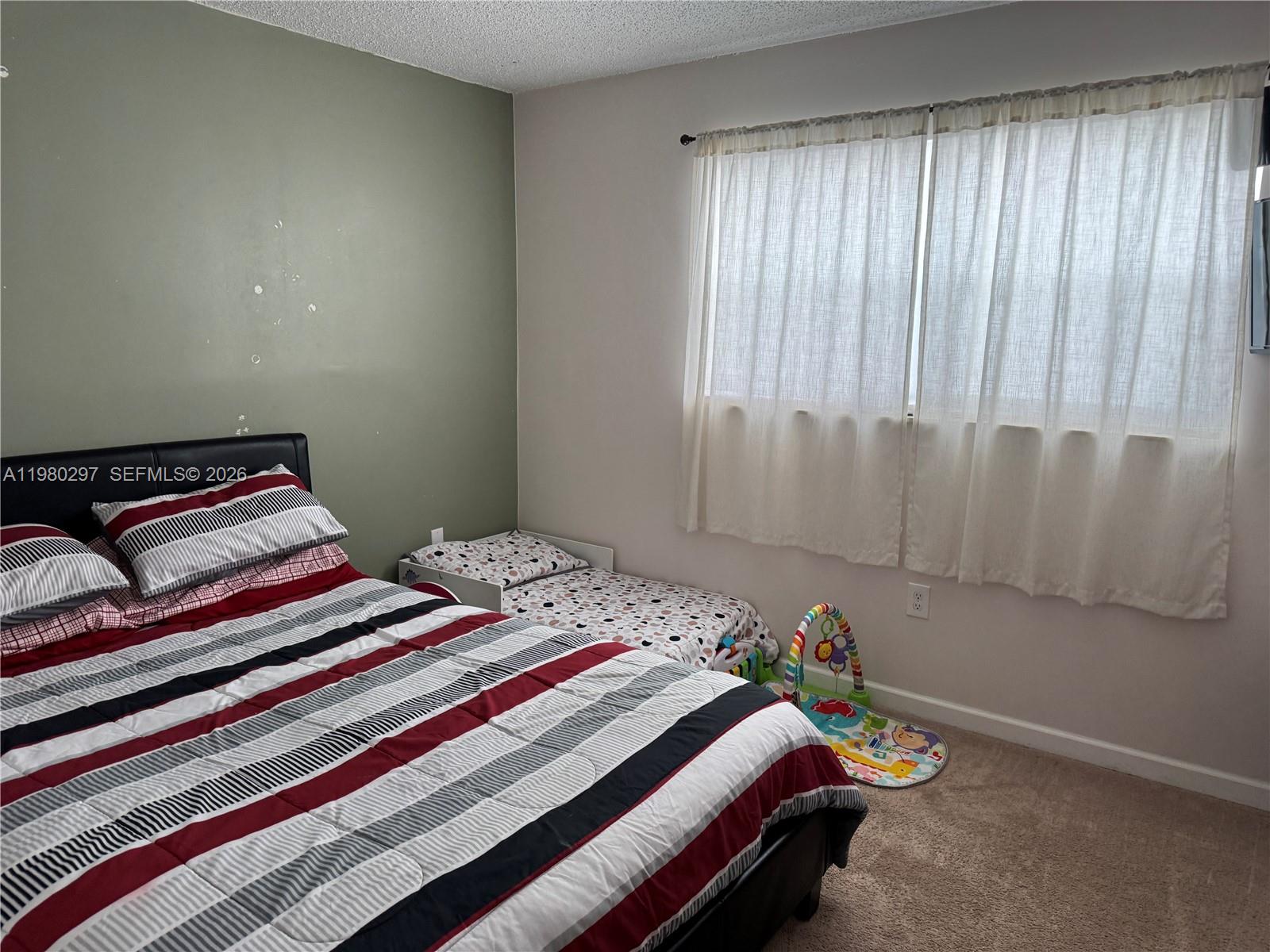 6507 Winfield Boulevard, Unit 111AC Margate, FL 33063 - Photo 36 of 42 a bedroom with a bed and a window