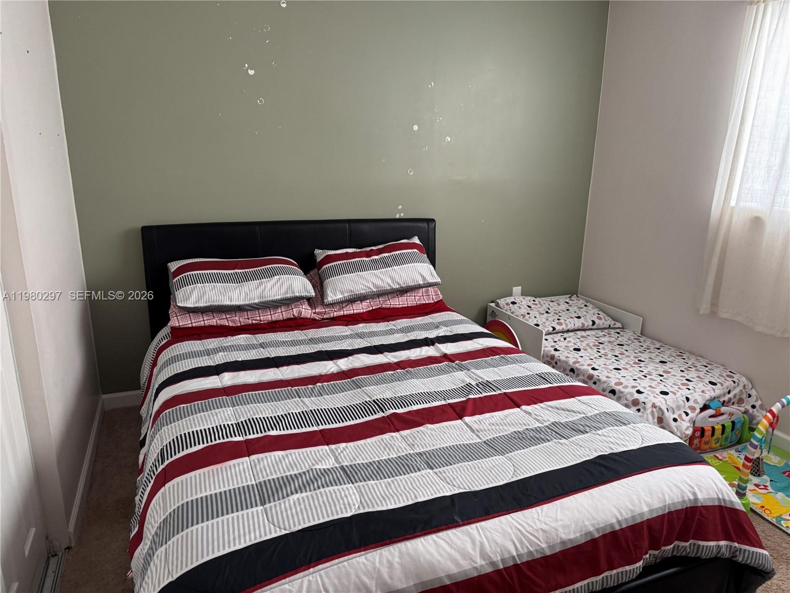 6507 Winfield Boulevard, Unit 111AC Margate, FL 33063 - Photo 37 of 42 a bedroom with a bed and a window
