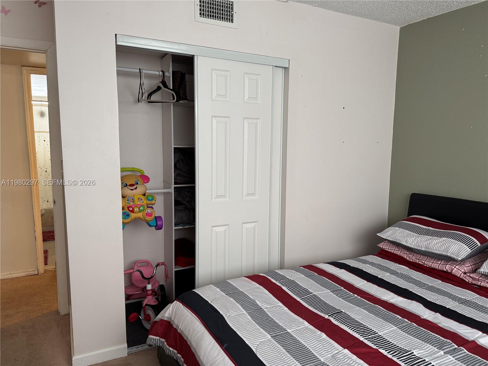 6507 Winfield Boulevard, Unit 111AC Margate, FL 33063 - Photo 38 of 42 a bedroom with a bed and a closet