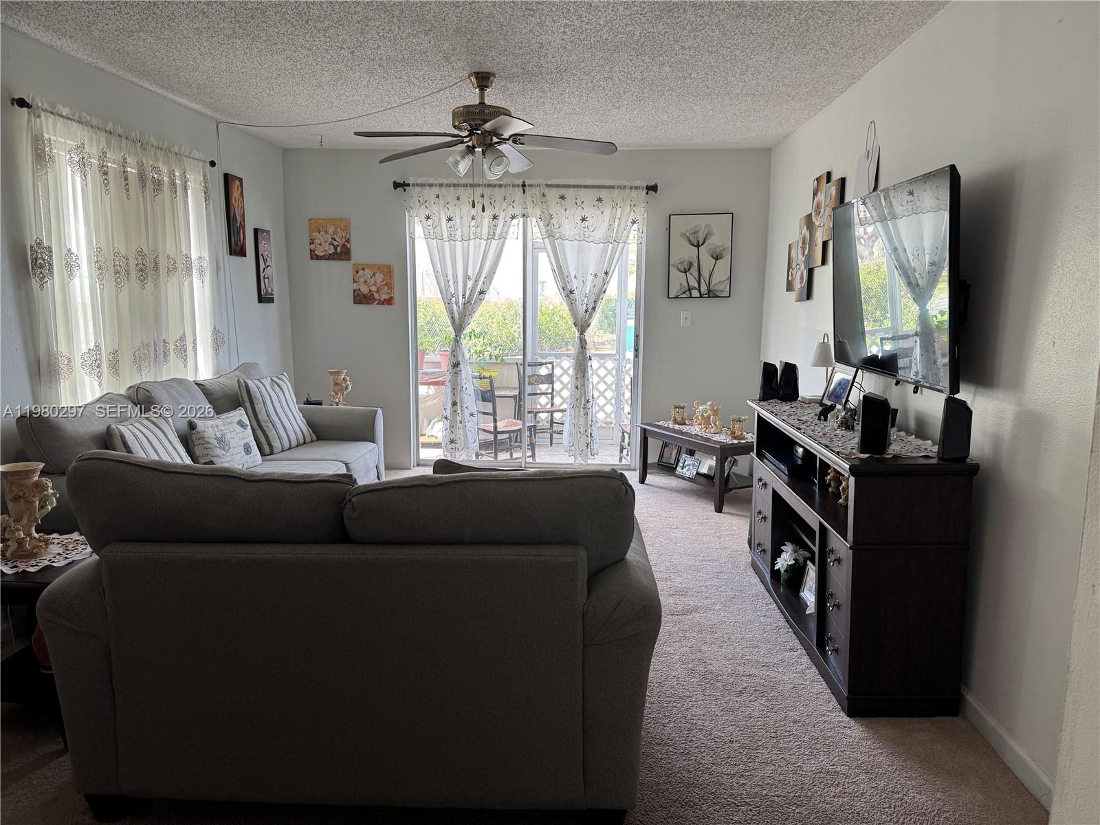 6507 Winfield Boulevard, Unit 111AC Margate, FL 33063 - Photo 9 of 42 a living room with furniture and a flat screen tv