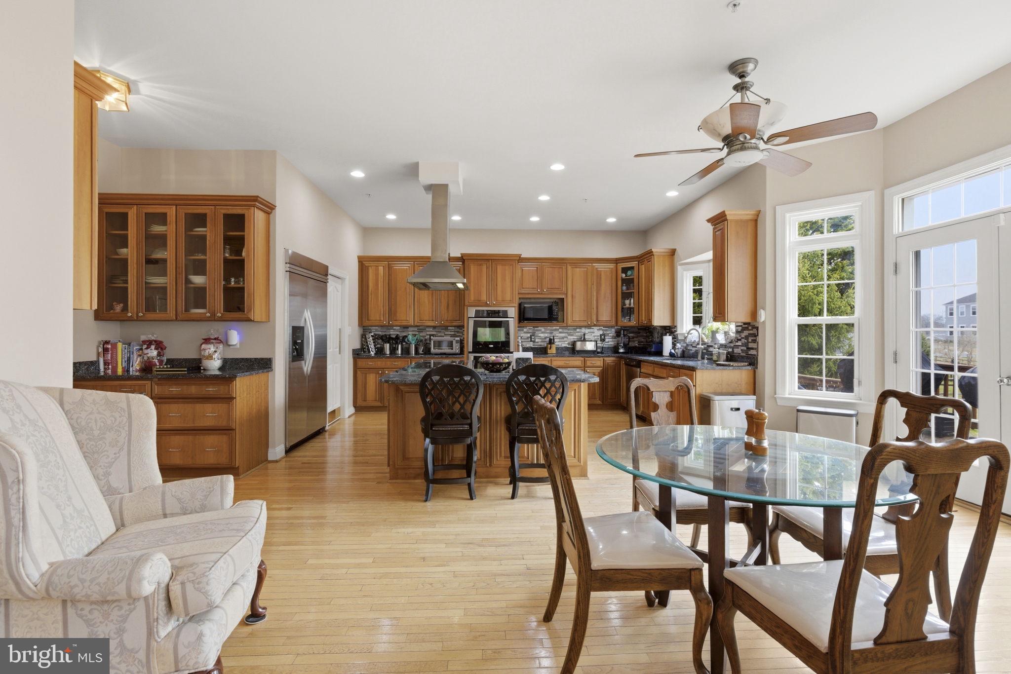 15611 Riding Stable Road Laurel, MD 20707 - Photo 21 of 86 a dining room with stainless steel appliances kitchen island granite countertop a dining table chairs and window