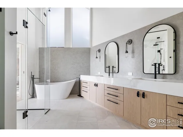 a spacious bathroom with a double vanity sink mirror and bathtub
