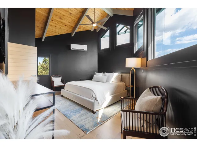 a bedroom with a bed lamp and a large window