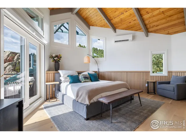 a bedroom with a bed a couch and a potted plant