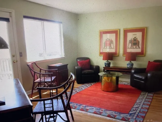 a living room with furniture a rug and a window