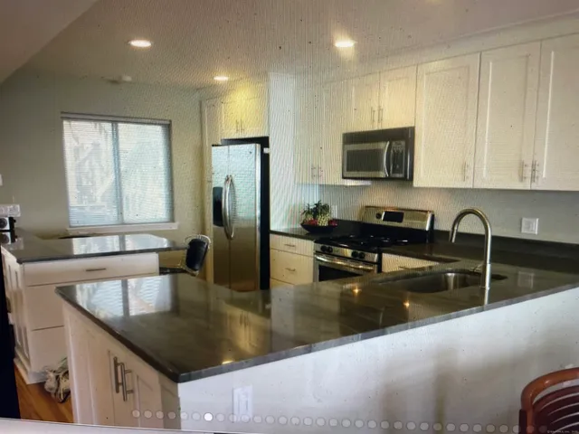a kitchen with granite countertop a sink a stove and a microwave