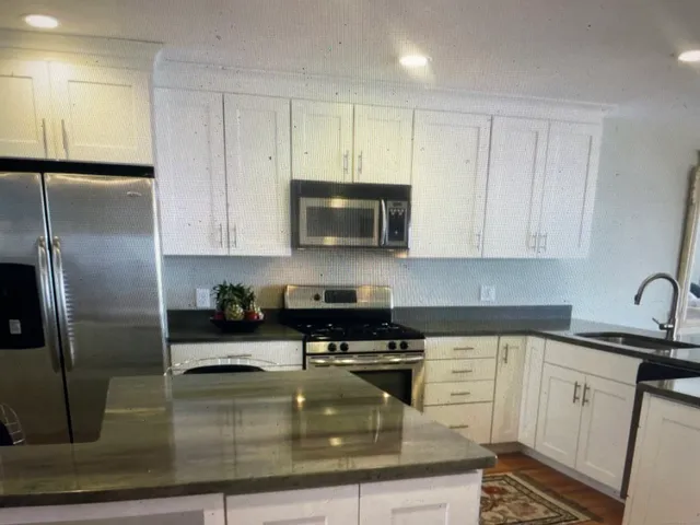 a kitchen with sink a microwave and refrigerator