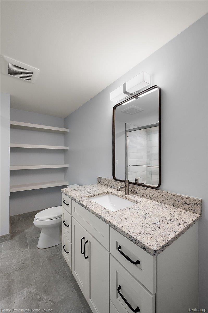 2919 North Addison Circle Rochester, MI 48306 - Photo 61 of 69 White vanity with a light speckled countertop, undermount sink, and dark-framed mirror