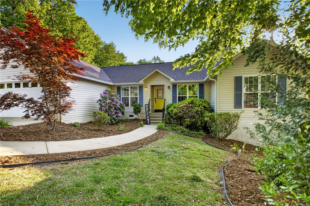 322 Shorecrest Drive Seneca, SC 29672 - Photo 2 of 30 A charming exterior with a bright yellow door, inviting you into a lush landscape.
