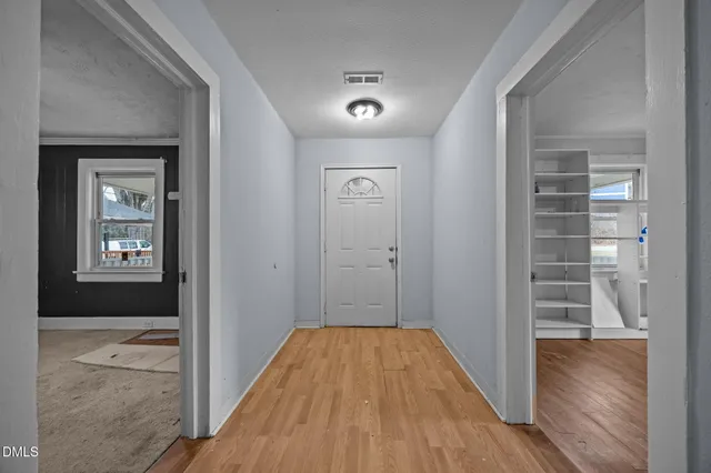 a view of a hallway with wooden floor and closet