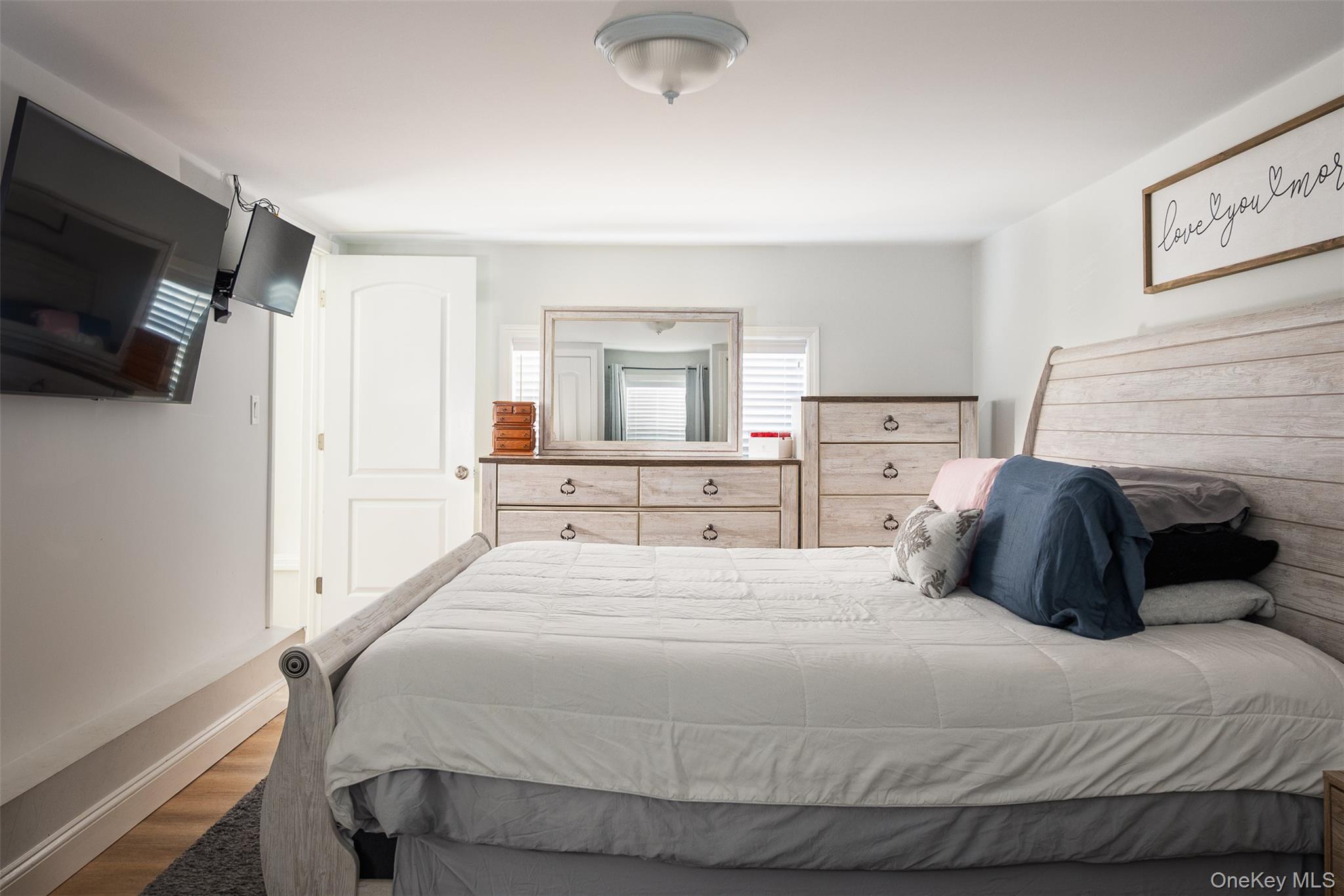 3 Cedar Road Sound Beach, NY 11789 - Photo 7 of 14 a bedroom with a bed and a flat tv screen on wall