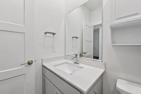 a bathroom with a sink toilet and mirror