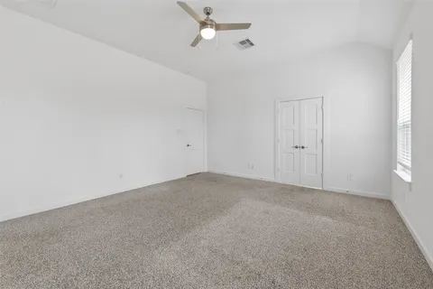 a view of an empty room with a chandelier fan