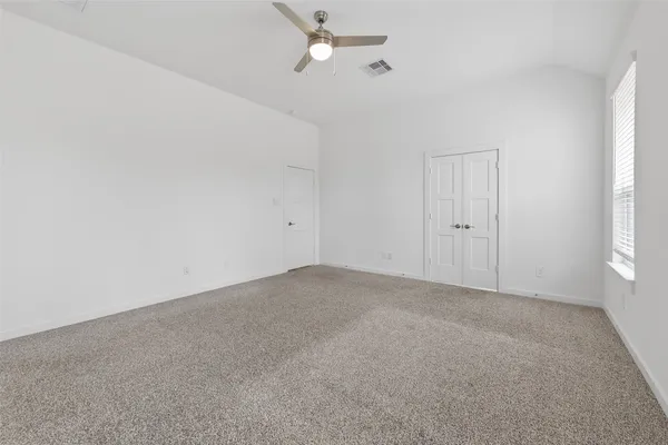 a view of an empty room with a chandelier fan