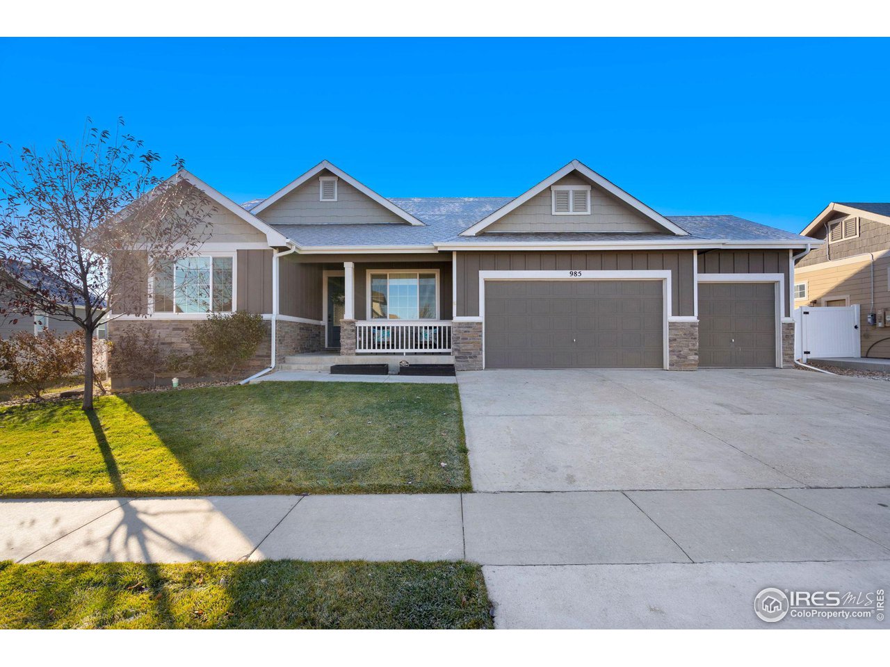 a view of a house with a yard and large tree