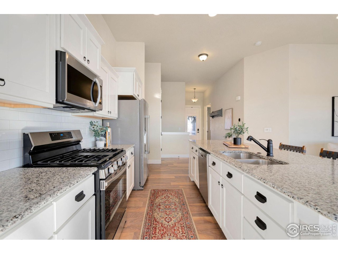 985 Mount Andrew Drive Severance, CO 80550 - Photo 11 of 25 a kitchen with stainless steel appliances granite countertop a sink stove and microwave