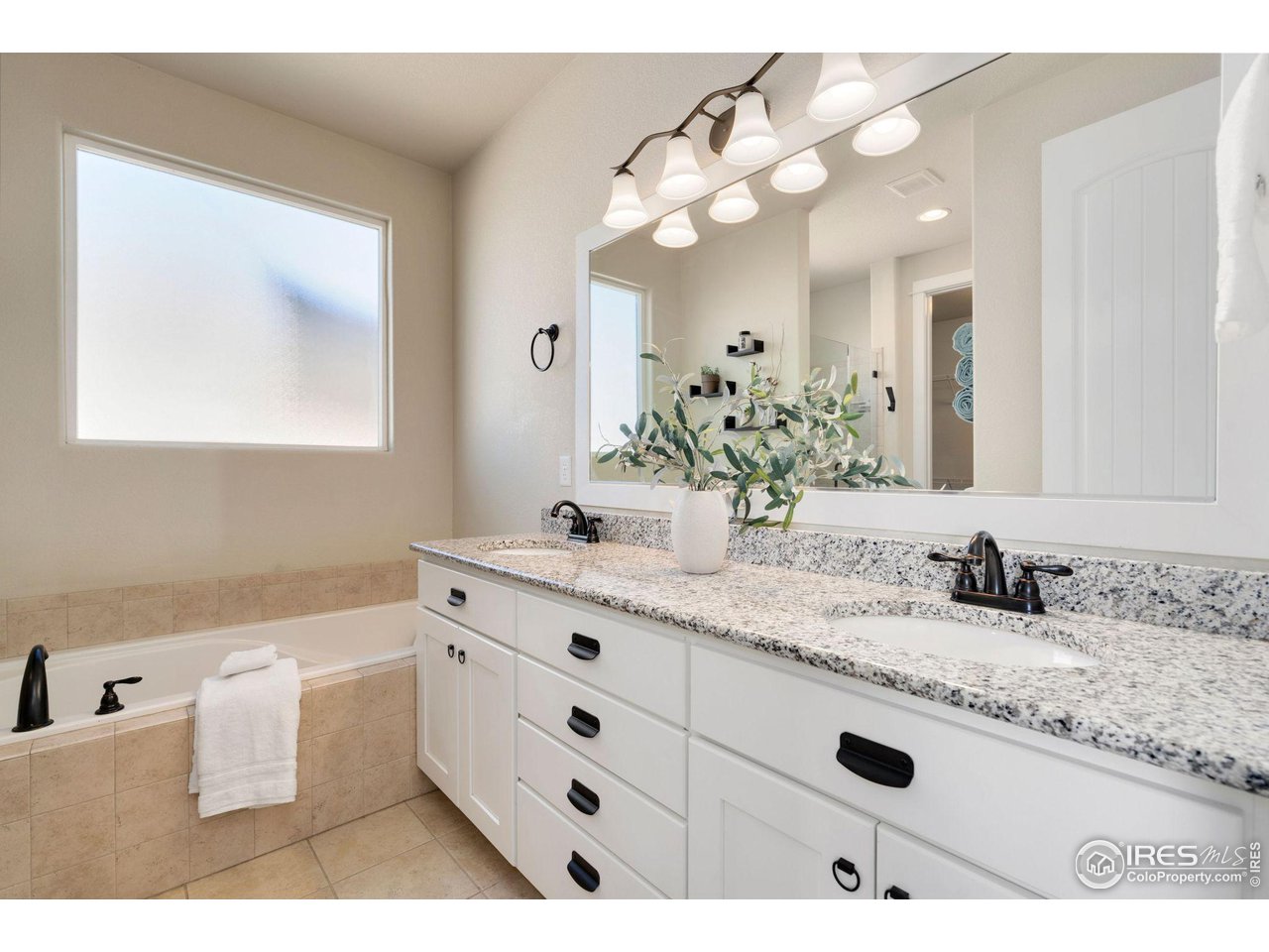 985 Mount Andrew Drive Severance, CO 80550 - Photo 18 of 25 a bathroom with a sink double vanity granite and a mirror