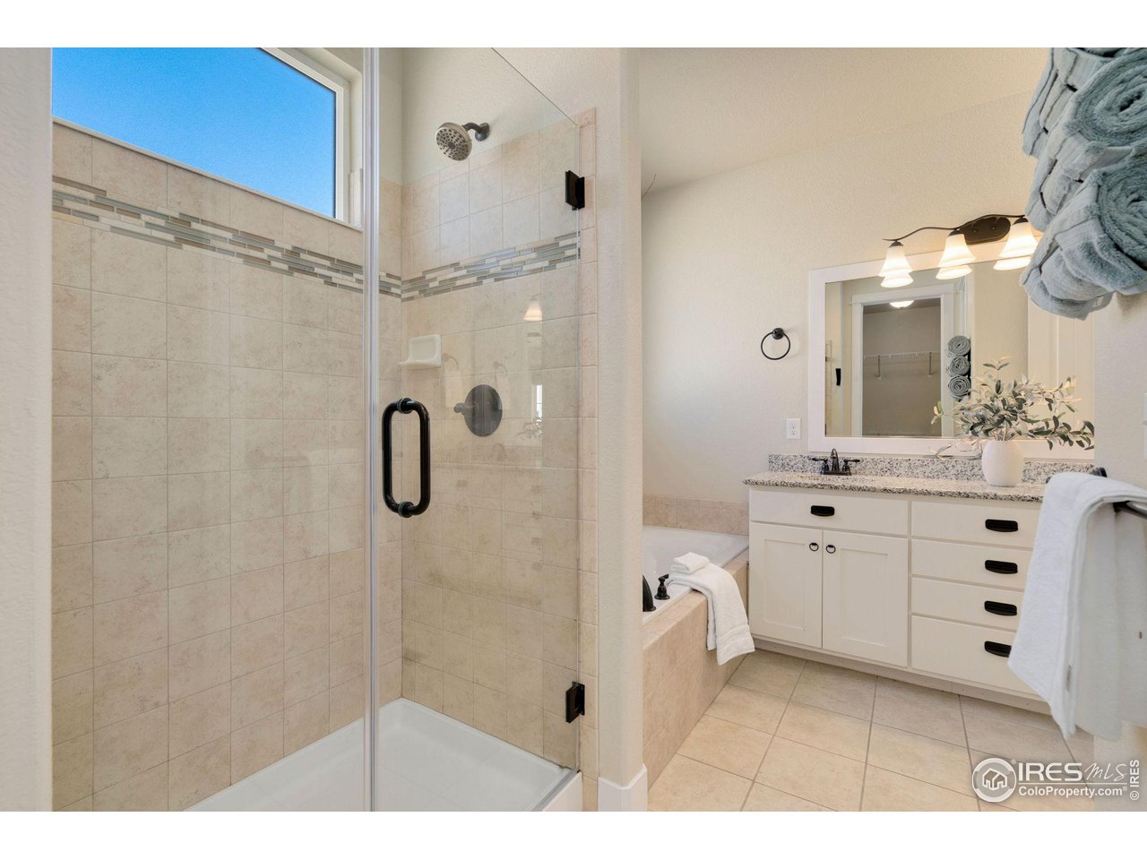 985 Mount Andrew Drive Severance, CO 80550 - Photo 19 of 25 a bathroom with a shower sink and mirror