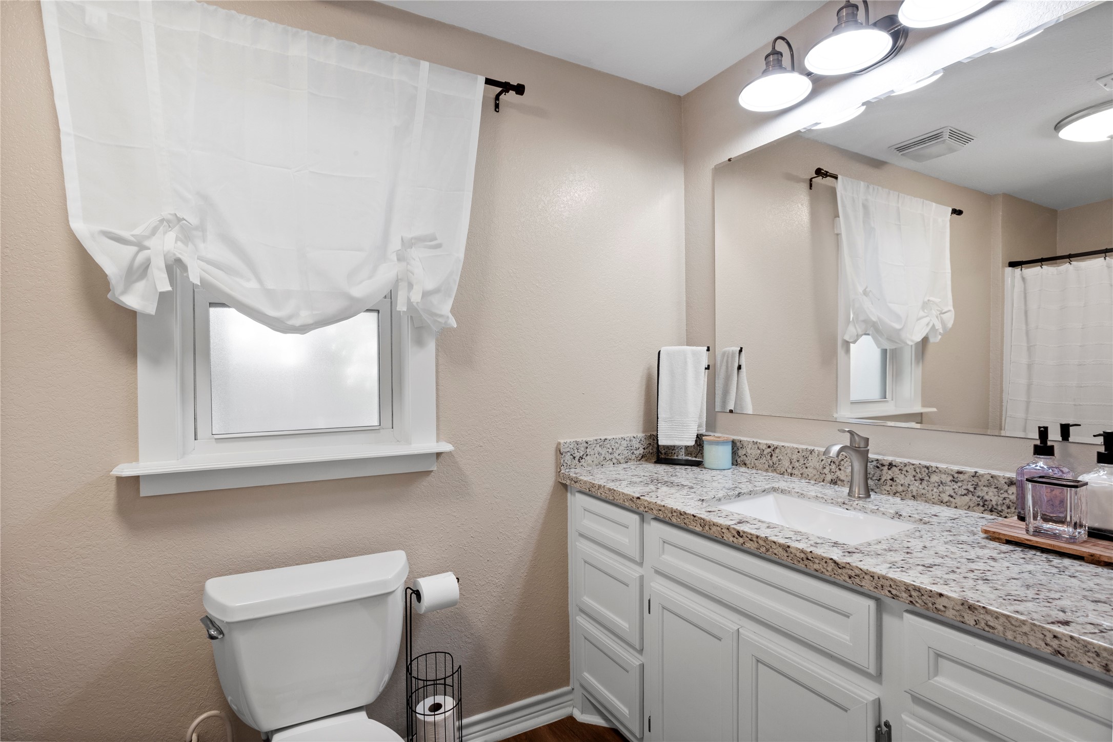 427 West 1st Street Freeport, TX 77541 - Photo 14 of 21 a bathroom with a granite countertop toilet sink and mirror