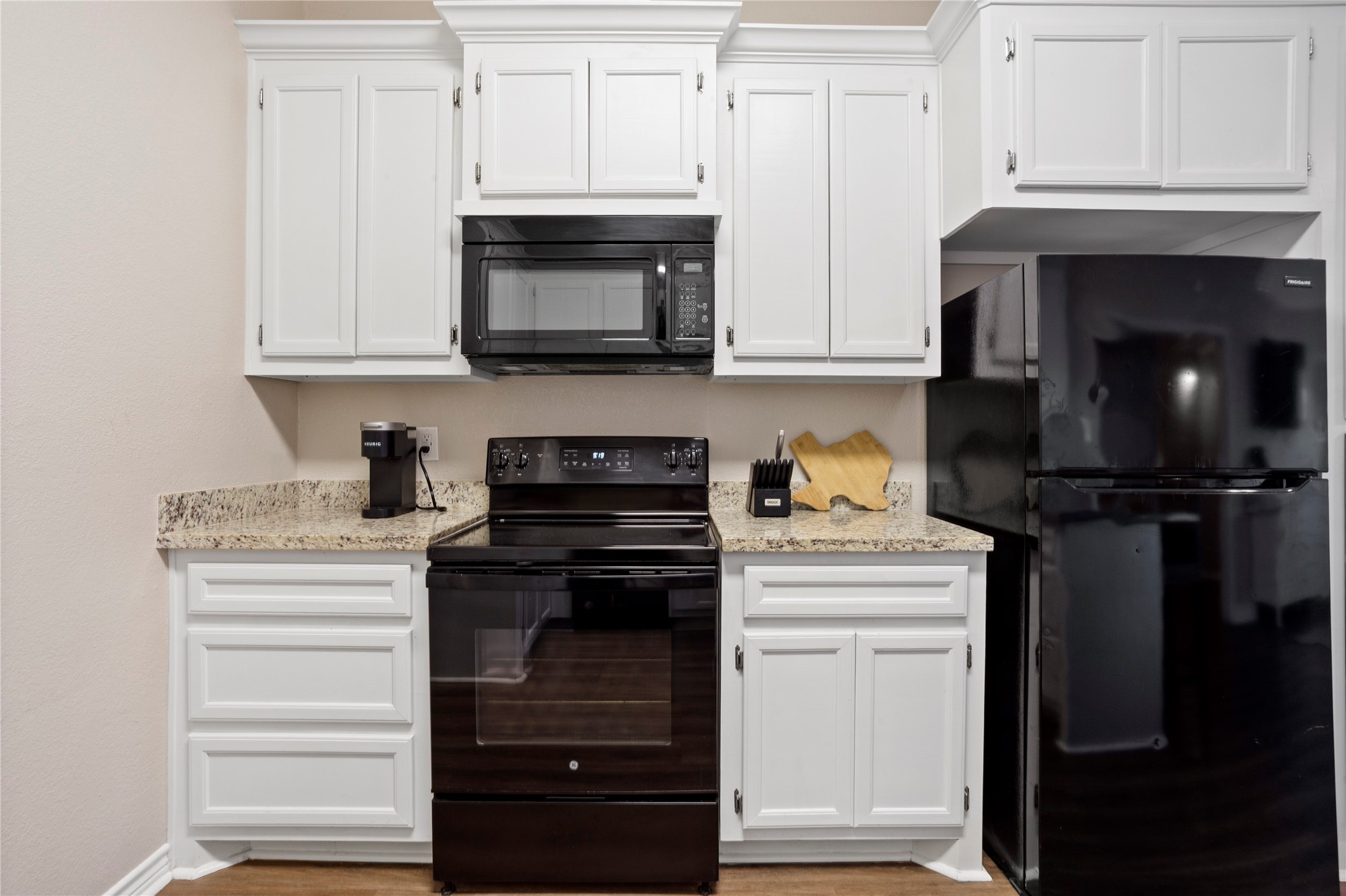427 West 1st Street Freeport, TX 77541 - Photo 8 of 21 a kitchen with white cabinets and black appliances