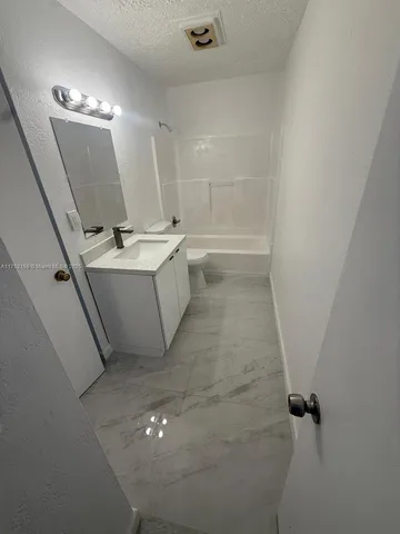 a bathroom with a sink a toilet a mirror and vanity