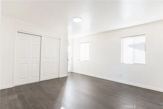 an empty room with wooden floor and white walls