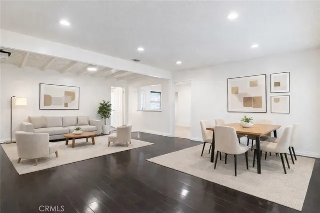 a view of a dining room with furniture a rug and wooden floor