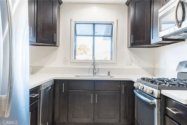 a kitchen with stainless steel appliances granite countertop a sink stove and cabinets