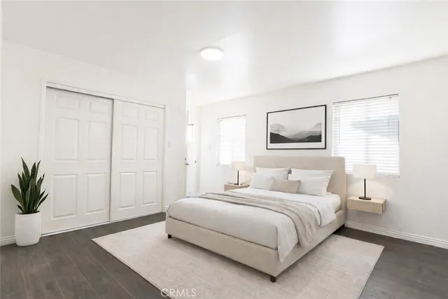 a bedroom with a large bed and a potted plant