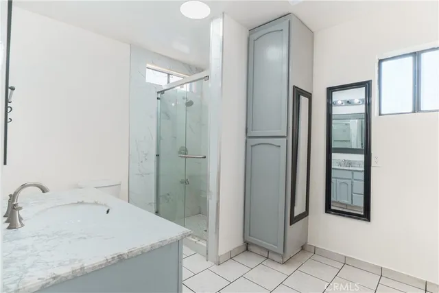 a bathroom with a granite countertop sink mirror and shower