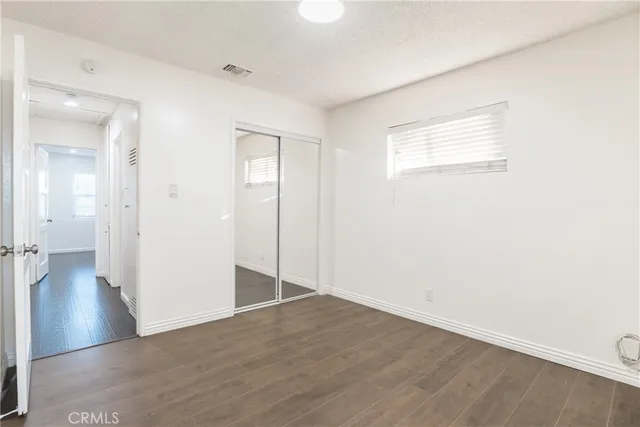 an empty room with wooden floor and a window
