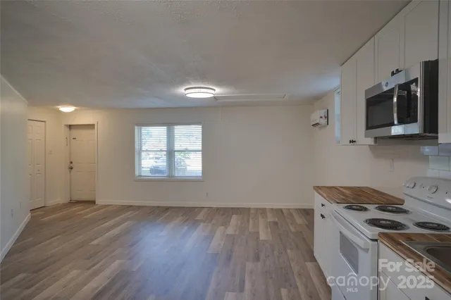 a kitchen that has a sink wooden floor and stainless steel appliances