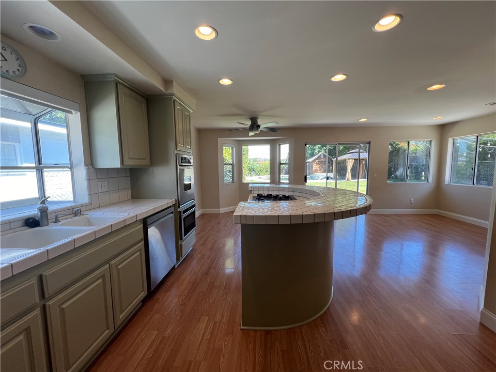 a kitchen with stainless steel appliances granite countertop a sink stove and wooden floor
