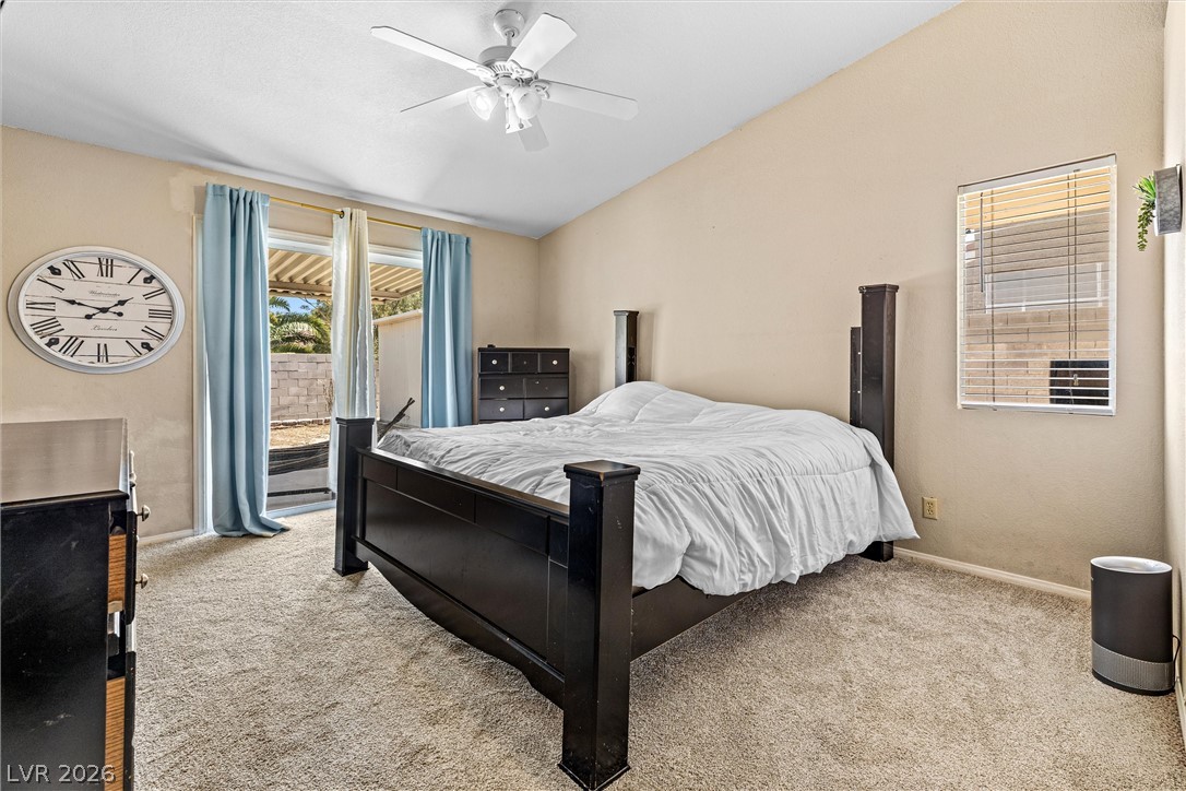 1624 Palmae Way Las Vegas, NV 89128 - Photo 8 of 18 This spacious bedroom features a textured carpet and a glass sliding door leading to an outdoor area, perfect for relaxed living.