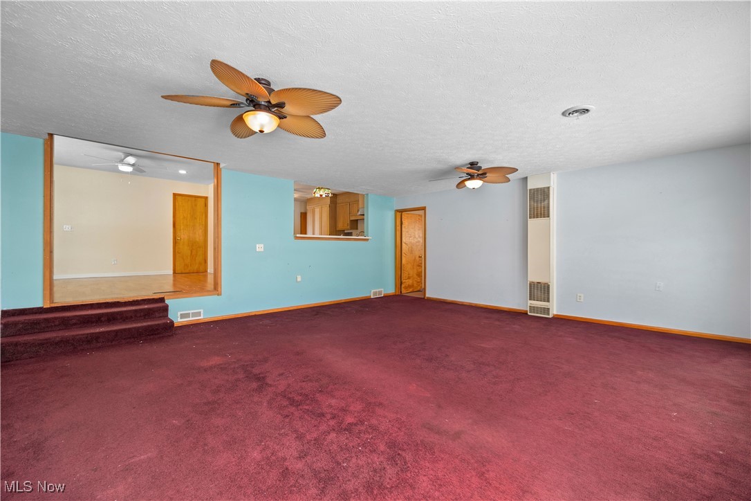 14015 West Lake Road Vermilion, OH 44089 - Photo 24 of 50 Carpeted spare room featuring a textured ceiling, a heating unit, and ceiling fan