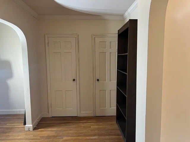 a view of an empty room with wooden floor