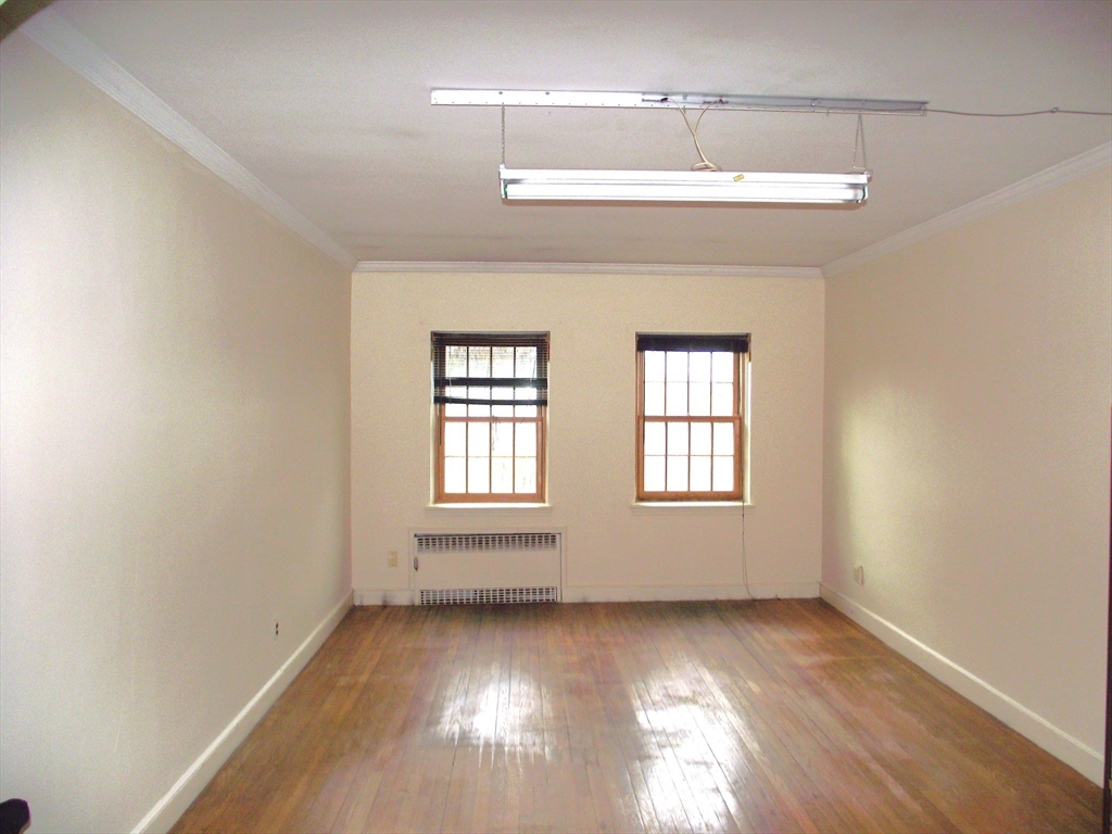 10 Presidents Lane, Unit 10 Quincy, MA 02169 - Photo 9 of 15 a view of an empty room with wooden floor and a window