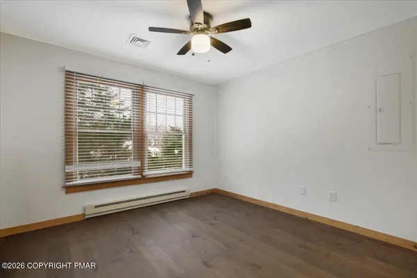 a view of an empty room with a window and a ceiling fan
