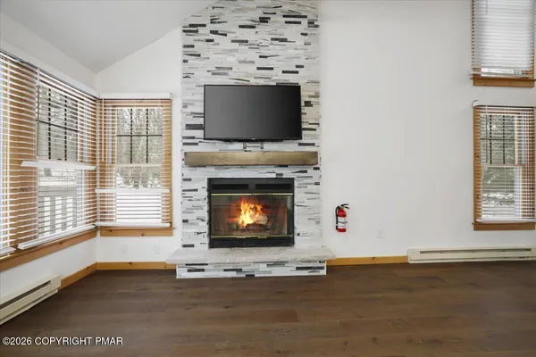 a living room with a fireplace a flat screen tv and a window