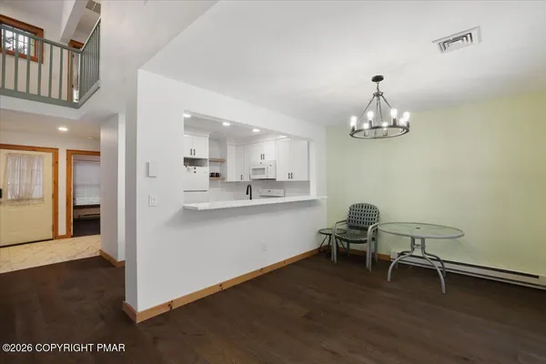 a view of a dining room with furniture wooden floor and a chandelier