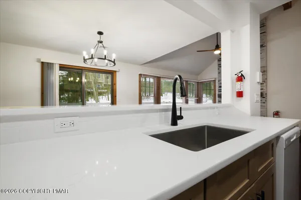 a kitchen with a sink a chandelier and window