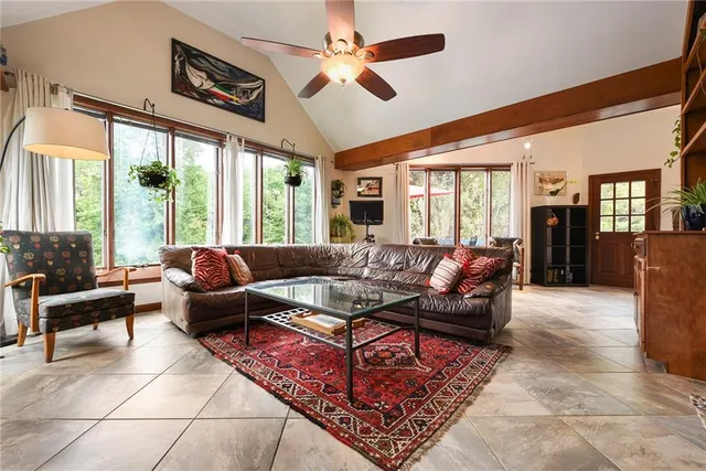 a living room with furniture ceiling fan and a large window